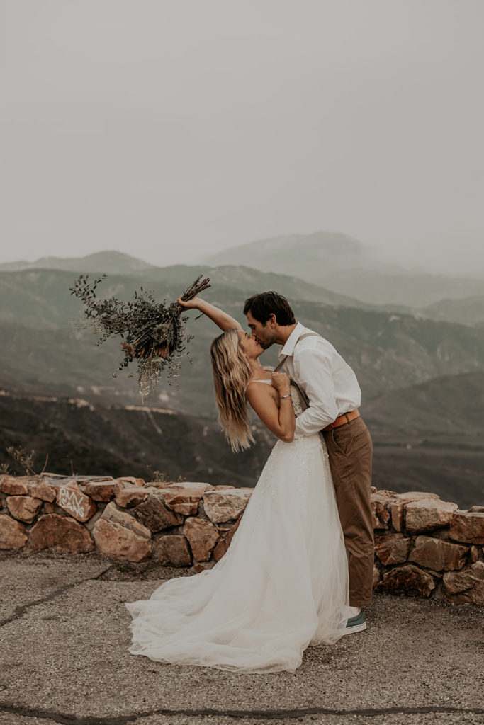couple kissing with mountain in the back