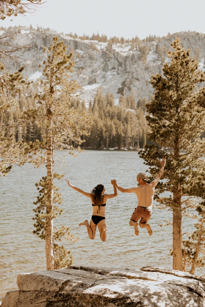 couple jumping into the water in mammoth lakes