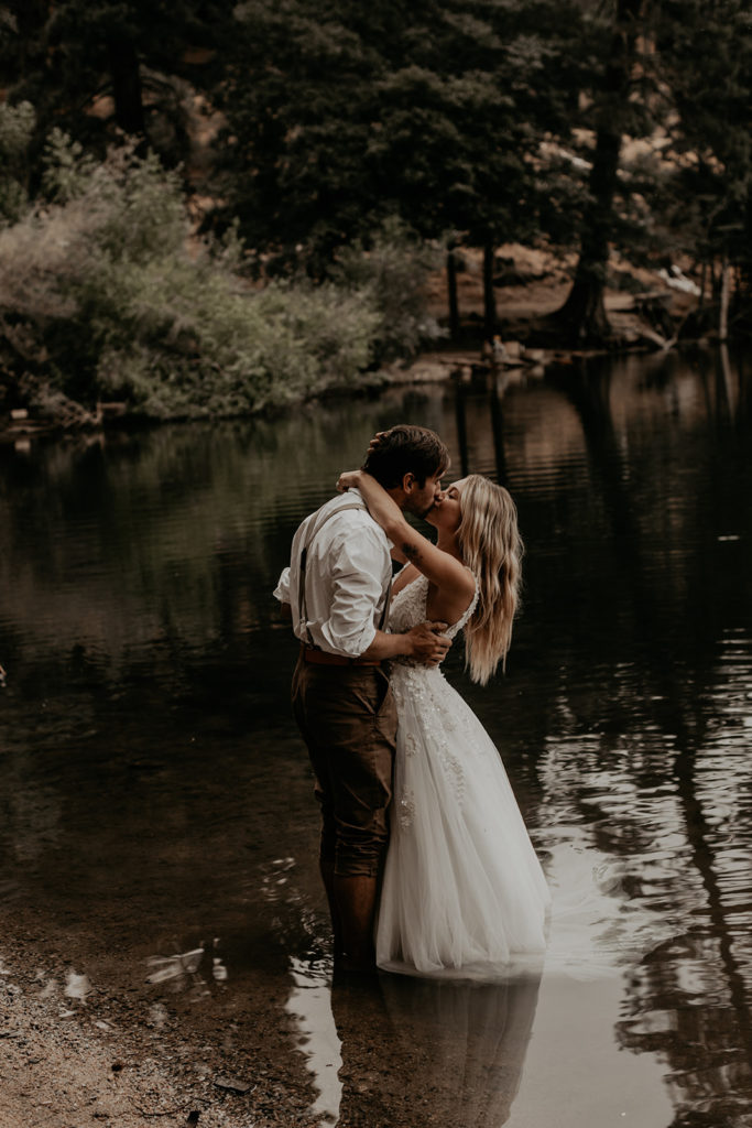 Bride and groom kissing in lake