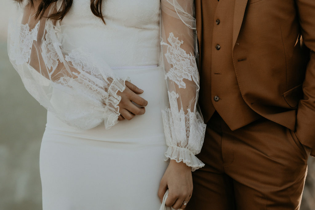 lace wedding gown and orange tux on bride and groom in Yosemite. 
