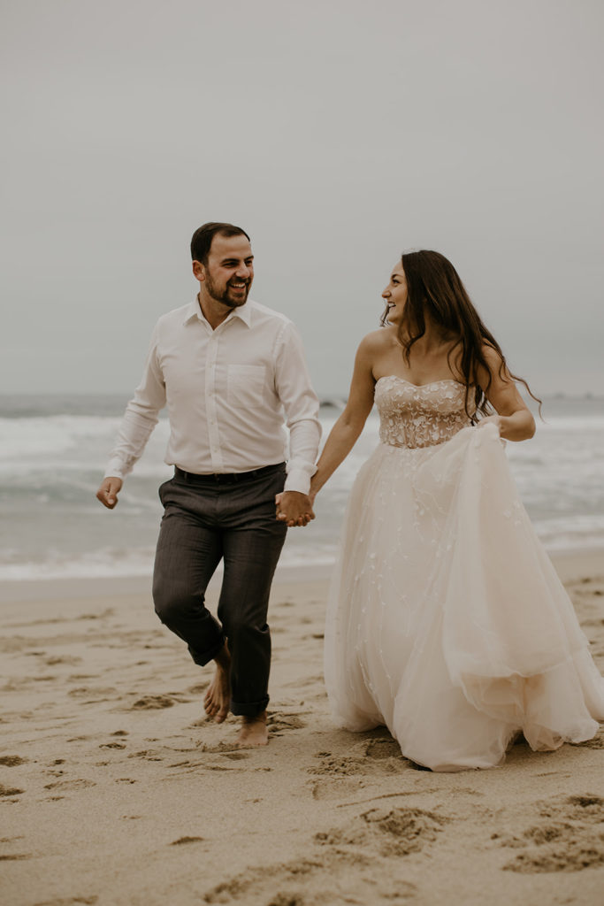Bride and Groom running on the sand in Big Sur