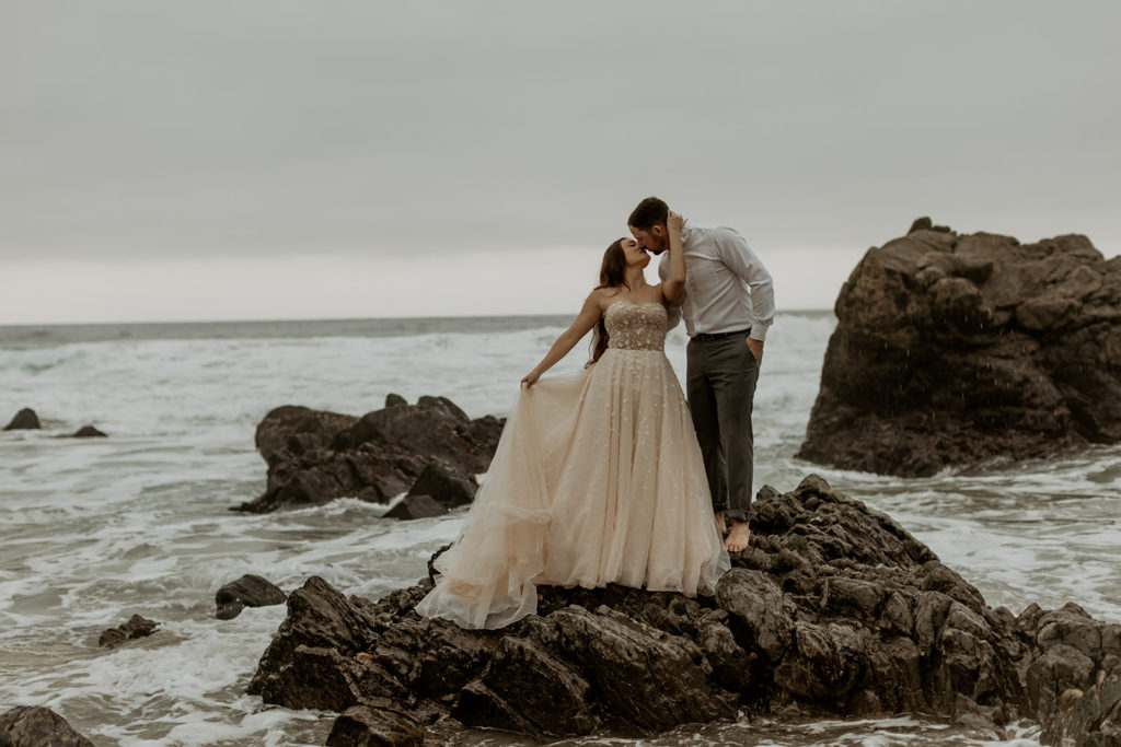 Bride and Groom on top of jagged rock in Big Sur