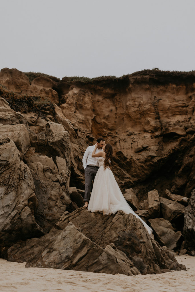 Bride and Groom on top of rock structure in Big Sur