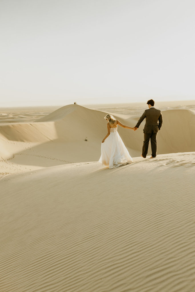 couple walking through the sand in the desert 