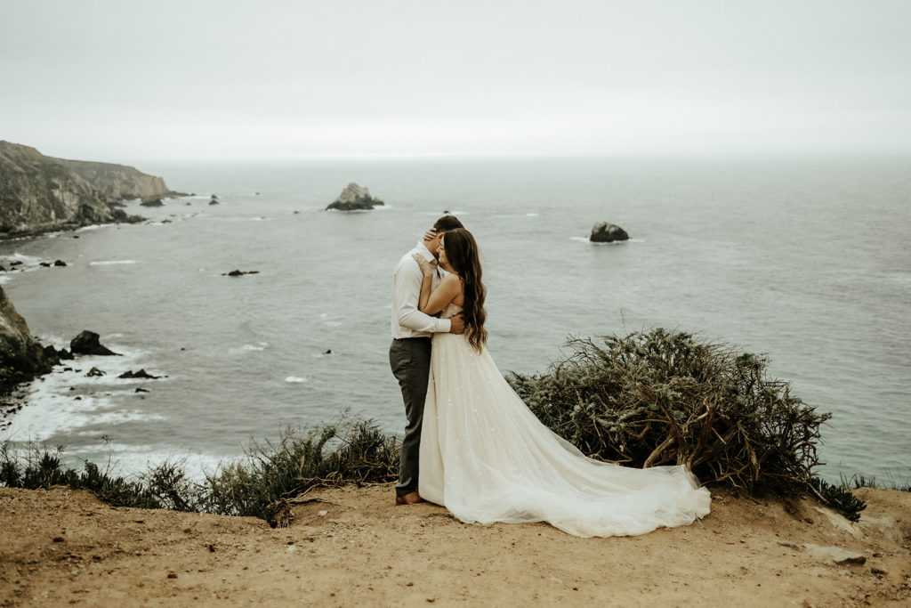 bride and groom in big sur on top of cliff
